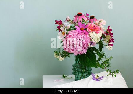 A bouquet of summer flowers in the room. Hydrangea, rose, echinacea, mint, snapdragon, asparagus and other flowers. Stock Photo