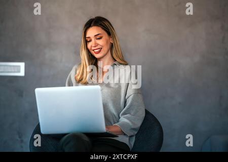 Young female designer, freelancer working in the office. Female using laptop to searching info. Stock Photo