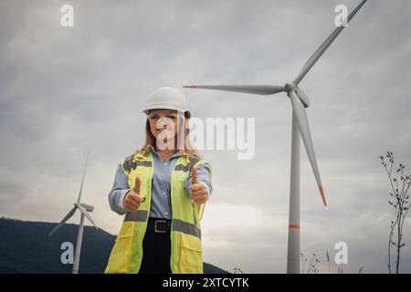 An empowered female engineer working at a wind farm is dedicated to promoting innovation in renewable energy while also emphasizing the importance of Stock Photo