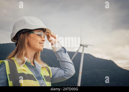 A Female Engineer at a Wind Farm focuses on innovative renewable energy solutions that benefit the environment and promote sustainability, emphasizing Stock Photo