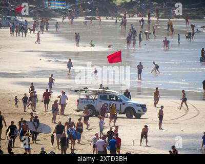 A Red Flag beach safety shutdown for thousands of visitors. RNLI Lifeguards take an unpopular but necessary action by advising swimmers and surfers to vacate the water. Although the popular beach famous for being the home of British surfing is thronged from end to end with record crowd numbers, a decision in light of big, rough, wave conditions combined with an outgoing tide resulted in the Red flags being hoisted to avoid folk getting into difficulties.  A number of major beach safety rescues have taken place in the resort in previous days, including 200 people being evacuated from Whipsiderr Stock Photo