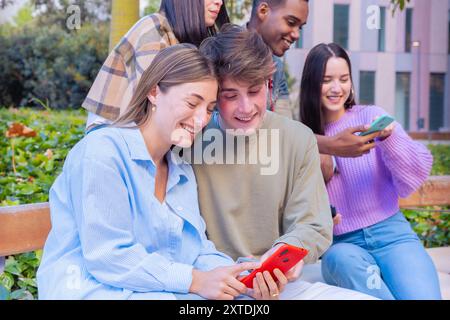 Five students having fun with mobile phones creating content on social media. Stock Photo