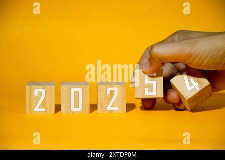 Text flip block 2024 to 2025 by hand, resolution, strategy, plan, goal, motivation, reboot, business and new year holiday concept. Stock Photo