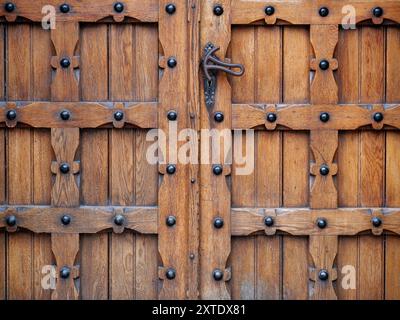 A detailed view of a highly ornate wooden door showcases intricate carvings and traditional craftsmanship, reflecting historical woodwork. Stock Photo