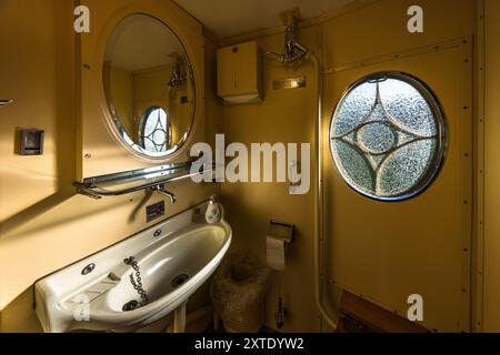 Train toilet in the Alpine Classic Pullman Express, built in 1931, with porcelain washbasin and porthole window. Washroom in the Alpine Classic Pullman Express on the route of the Glacier Express, Grisons, Switzerland Stock Photo