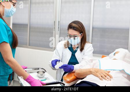 Dermatologist carrying out a skin biopsy on the face of a senior adult ...