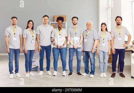 Happy smiling volunteers working in community charity donation center and looking at camera. Stock Photo