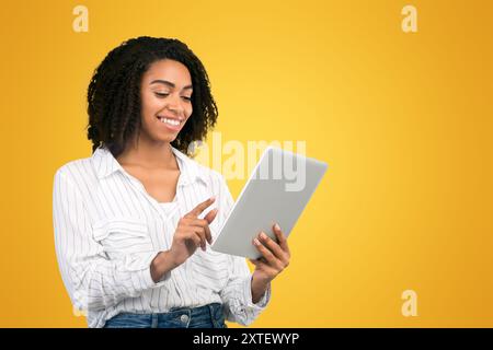 Smiling afro woman reading email on digital tablet Stock Photo