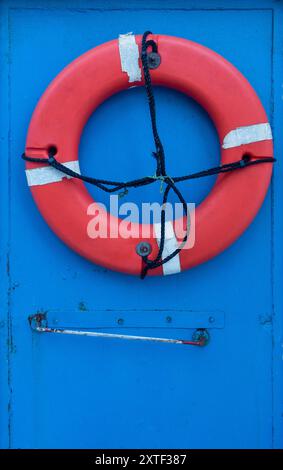 Red lifebelt on blue door Stock Photo