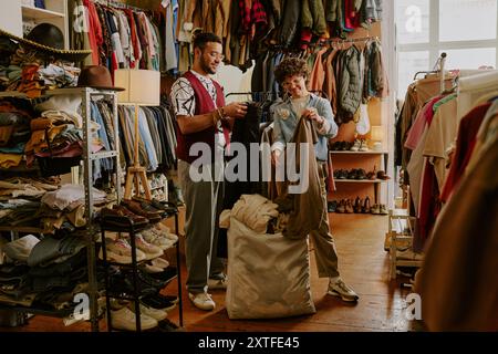 Choosing Clothes in Vintage Clothing Store Together Stock Photo