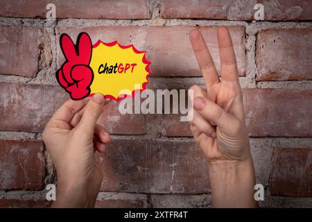 ChatGPT. Sticky note with text on a red brick background. Stock Photo