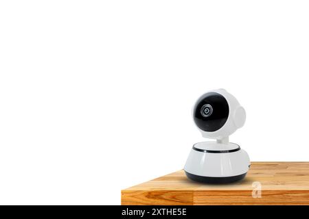 CCTV camera placed on table. Advanced white CCTV camera on wooden table isolated on white background, clipping path. Stock Photo