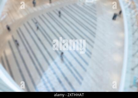 Blurred view from above of people walking on a tiled floor in a modern shopping mall. Stock Photo