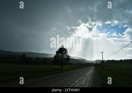 Sun shining through clouds after a rainstorm. Landscape silhouetted with sun shining in the sky Stock Photo