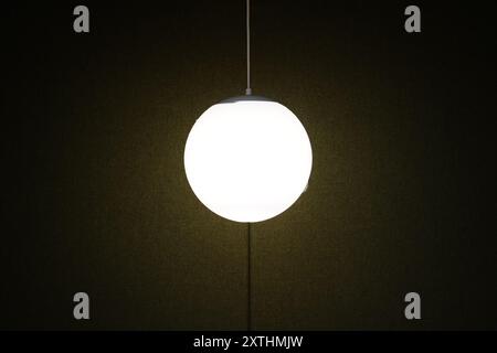 Lamp hanging on the ceiling in the dark room Stock Photo