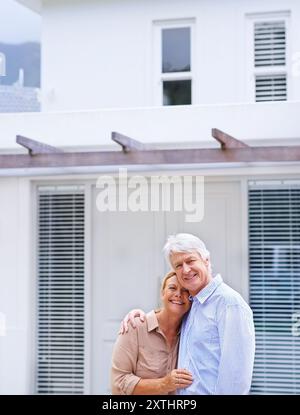 Senior couple, portrait and new home outdoor for dream real estate investment, mortgage or loan. Face, happy man and woman hug for property sale Stock Photo