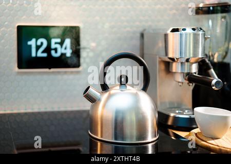 Home cooking. Kettle on shrub plate. Coffee machine and blender. Digital clock on touch screen. Stock Photo