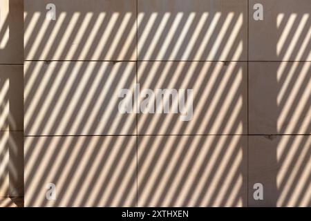 Diagonal shadows on cream stone wall for use as a background texture Stock Photo