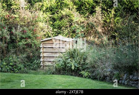 Winsford, Cheshire West and Chester, UK - August 14th 2024 - Garden composting bin in the shape of a bee hive in the brder of a garden Stock Photo