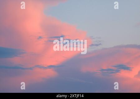 A stunning, reddish, cloudy sky at sunset, with vibrant hues and dramatic clouds creating a serene and atmospheric evening view.sunset,red colors ,sky Stock Photo
