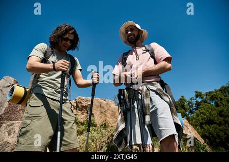 A happy gay couple enjoys a hike in the wilderness on a sunny summer day. Stock Photo