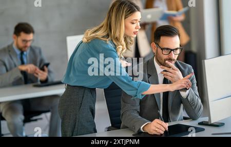 Group of multiethnic business people analyzing data using computer while working in the office Stock Photo