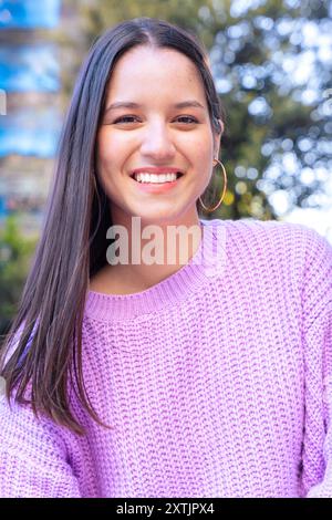 Vertical portrait young latin woman smiling confident standing at street. Stock Photo
