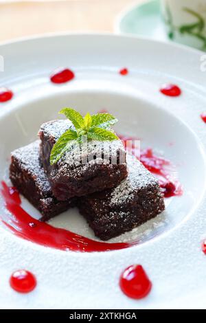 Close-up of Chocolate Brownie with Raspberry Sauce Stock Photo