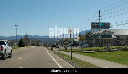 PIGEON FORGE, TN - 12 MAR 2024: The Parkway heading toward the Smokey Mountains on a sunny afternoon in Tennessee. POV from vehicle in the right lane. Stock Photo