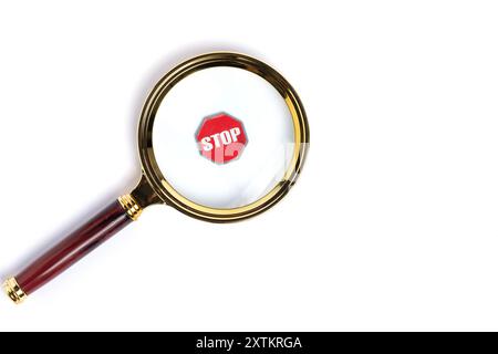 Magnifying glass with stop sign isolated on white background Stock Photo