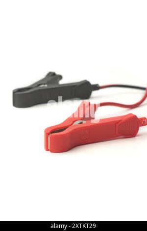 close-up of car battery jumper cables isolated white background, red and black booster cables clamps with wires, taken in selective focus Stock Photo