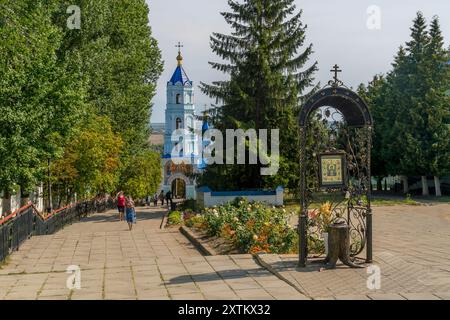 The religious Russian people at the stairway at monastery of Korennaya Pustyn, Russia, with the beautiful old chapel tower and peaceful atmosphere. Stock Photo