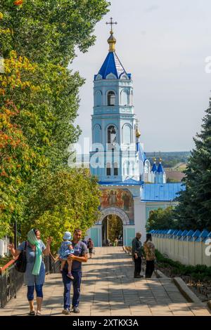 The religious Russian people at the stairway at monastery of Korennaya Pustyn, Russia, with the beautiful old chapel tower and peaceful atmosphere. Stock Photo