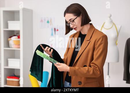 Fashion designer with color palettes and fabric in workshop Stock Photo