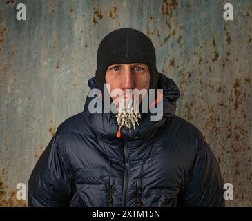 White man with winter blue jacket and 29 marijuana joints in mouth Stock Photo