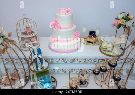 A delicious three-tiered wedding cake with pink roses Stock Photo