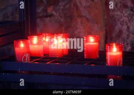 Covadonga, Spain, 15th August, 2024: Several candles lit in the Holy Cave during Daily life in Onís, on August 15, 2024, in Covadonga, Spain. Credit: Alberto Brevers / Alamy Live News. Stock Photo