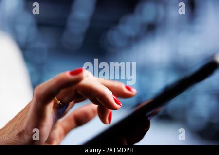 System administrator using tablet, ensuring valuable data remains shielded from potential security concerns, safeguarding server rackmounts against unauthorized access and vulnerabilities, close up Stock Photo