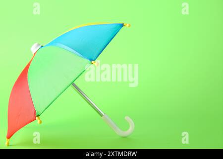 Mini colorful umbrella on green background Stock Photo