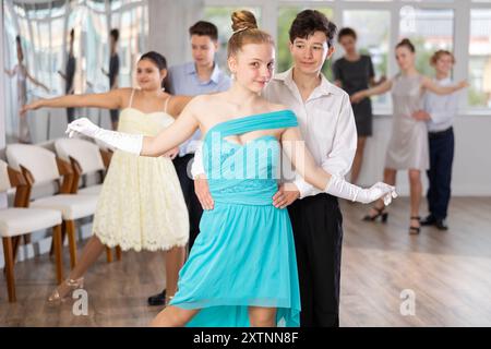 Adolescent ballroom dancers practicing elegant dance moves in pairs Stock Photo