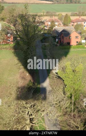 Virgin hot air balloon casts its shadow across a small group of houses in the village of Hardwick in South Norfolk before landing in a nearby field. Stock Photo