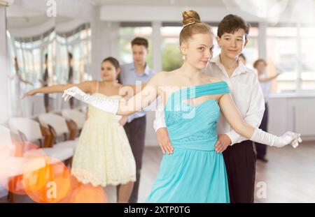 Adolescent ballroom dancers practicing elegant dance moves in pairs Stock Photo