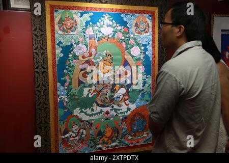 New York, USA. 15th Aug, 2024. A visitor views a thangka painting by Liu Jingtao, a Chinese artist from central China's Hubei province, at an exhibition in New York City, the United States, on Aug. 15, 2024. Chinese artist Liu Jingtao on Thursday kicked off his solo exhibition of 17 artworks on Chinese landscapes, Tibetan buddhist art, and fine-brush flower-and-bird paintings in New York City. Credit: Liu Yanan/Xinhua/Alamy Live News Stock Photo