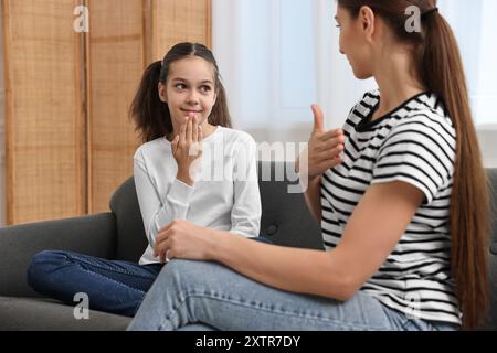 Woman and her daughter using sign language for communication at home Stock Photo