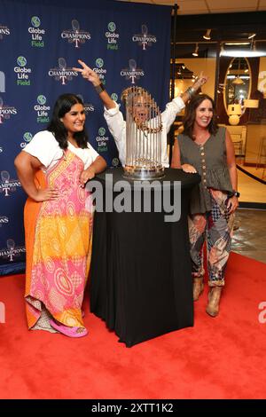 DALLAS, TX, USA - AUGUST 15, 2024. Attendees pose with the MLB Commisioner's Trophy at the August WESA Trade Show and Dallas Market. Stock Photo