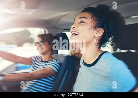 Friends, women and smile with driving car on speed for fun on roadtrip, travel and holiday in Spain. People, vehicle and happy or excited for Stock Photo