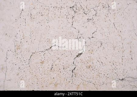 Texture of natural white stone with brown dots and cracks Stock Photo