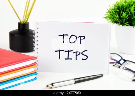 top tips word. text concept symbol TOP TIPS in a notebook on a light background in a composition with business accessories Stock Photo