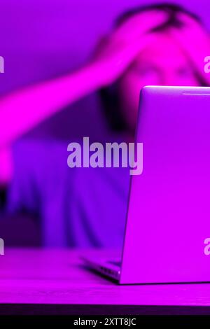 software development concept,  laptop with software code on screen in neon purple light, suitable for software development , IT education topics Stock Photo