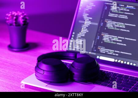 software development concept,  laptop with software code on screen in neon purple light, suitable for software development , IT education topics Stock Photo